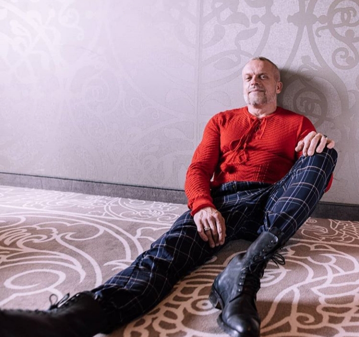 punk-style-man-in-red-jumper-sitting-on-the-floor